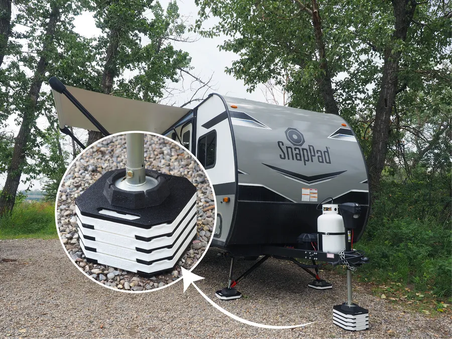 Travel trailer parked on StakPads, with a close-up of the stacked pads under the jack