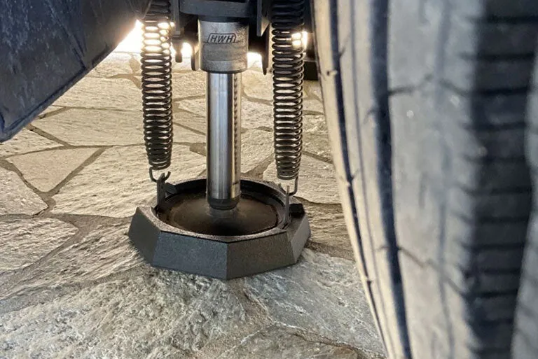 Close-up of a HWH jack with a SnapPad next to a tire